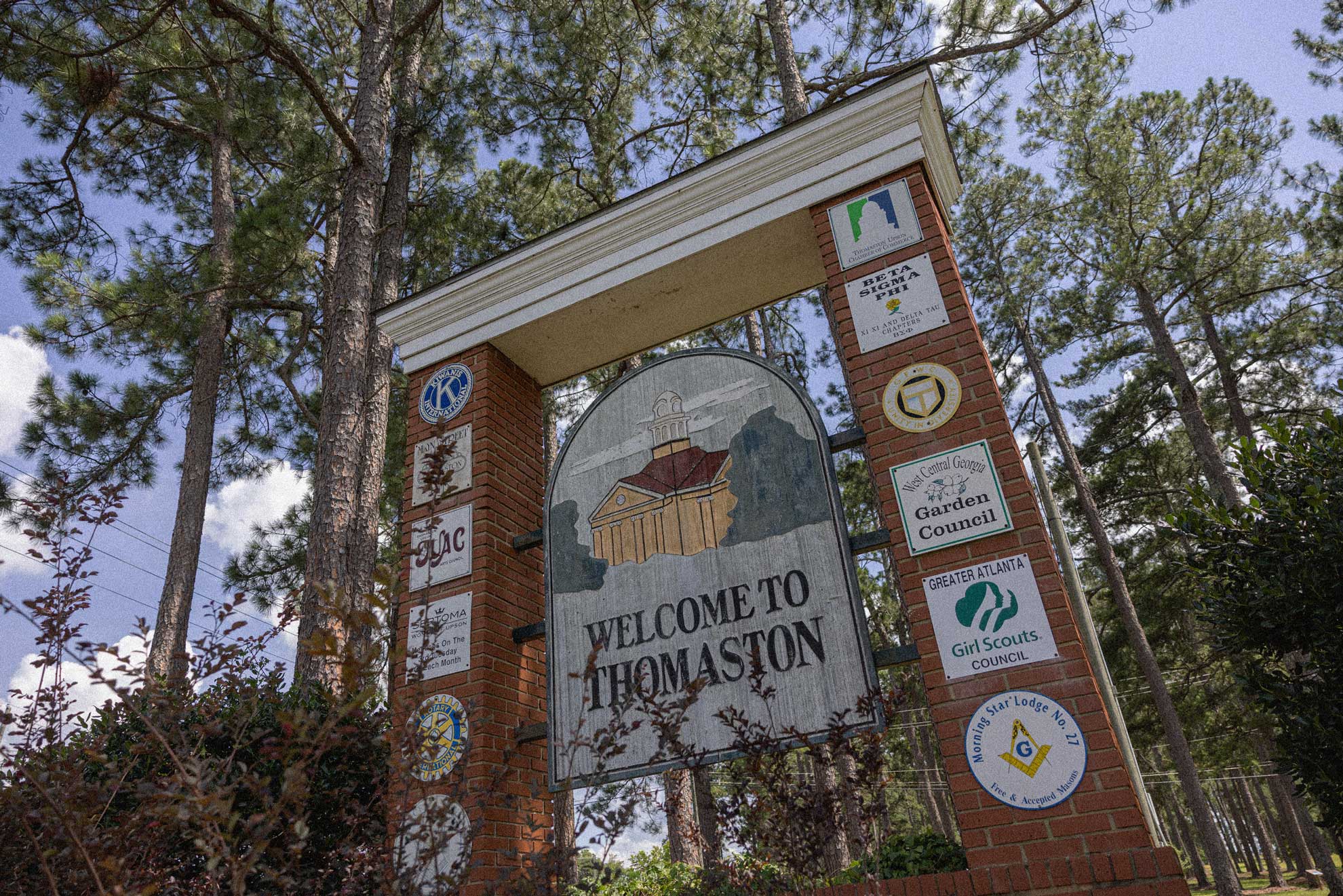 Sign from Thomaston in the trees blue sky